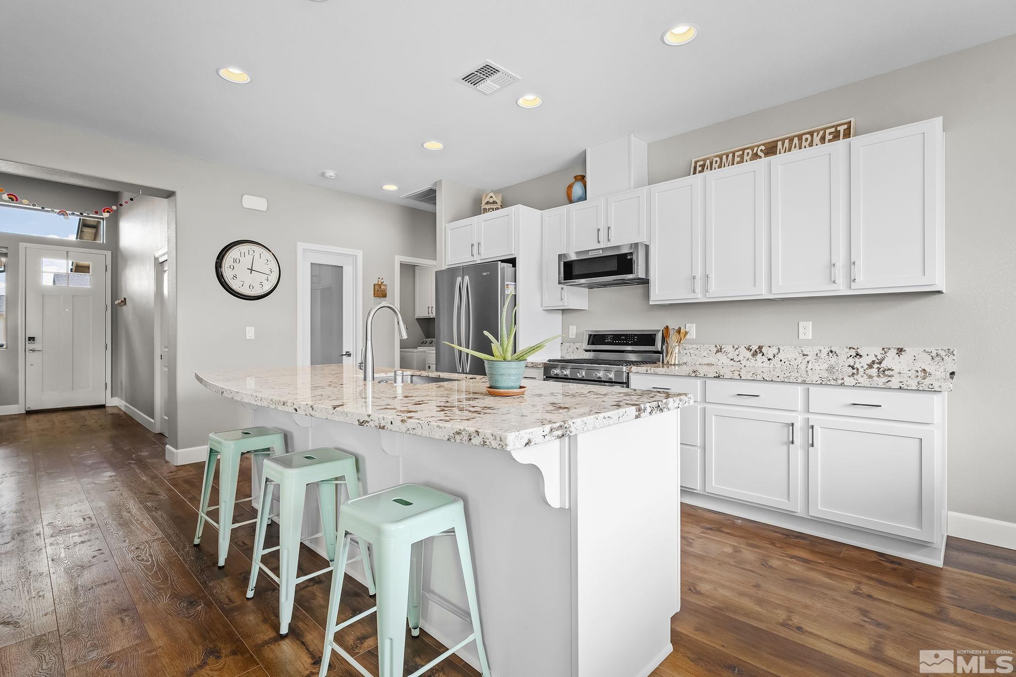 626 Riverbed Circle Reno, NV 89521 - Photo 8 of 27 a kitchen with stainless steel appliances granite countertop a white cabinets stove a sink and a refrigerator