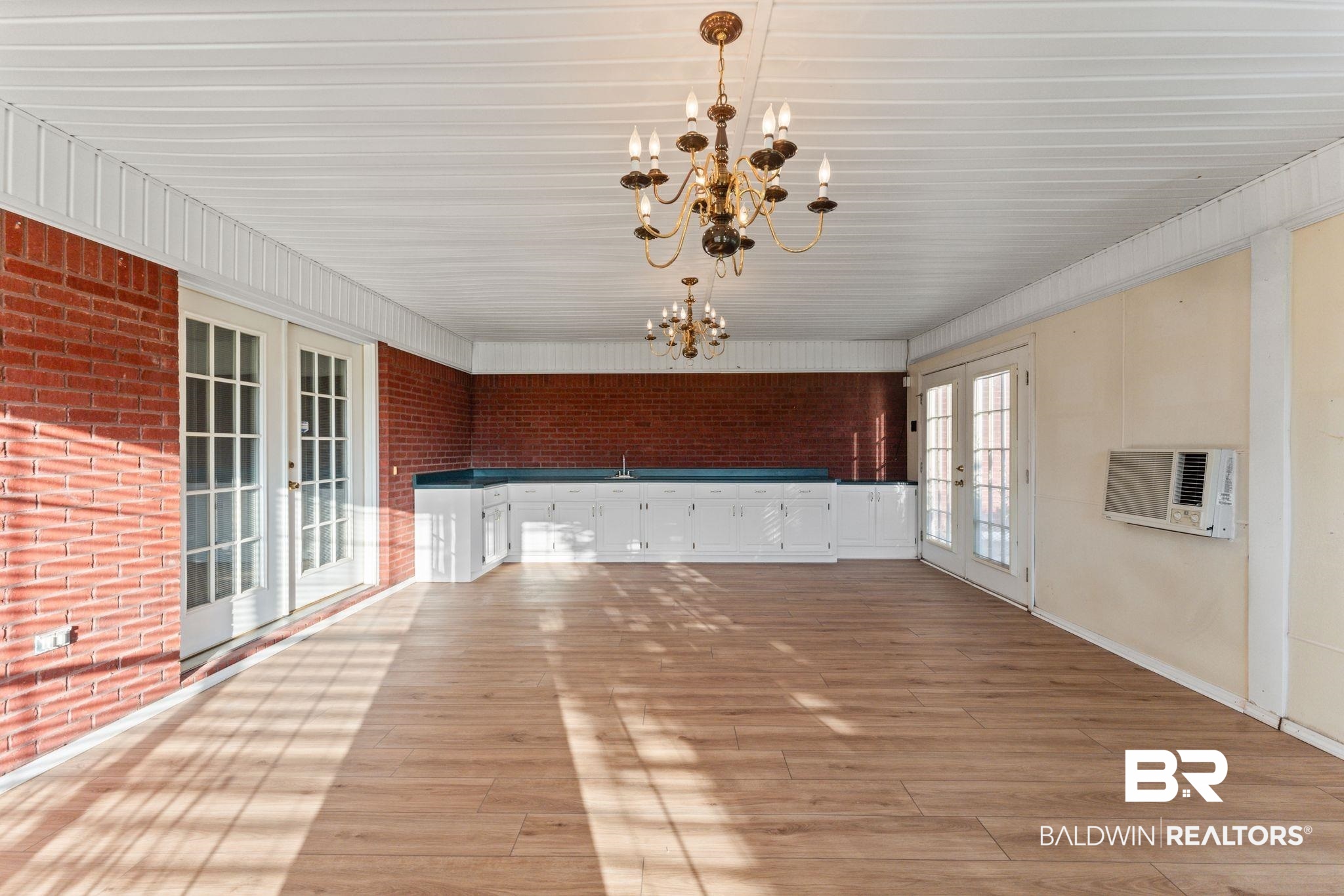 888 Mobile Cut-Off Road St. Stephens, AL 36569 - Photo 27 of 54 Unfurnished dining area with french doors, brick wall, light wood-type flooring, and a chandelier