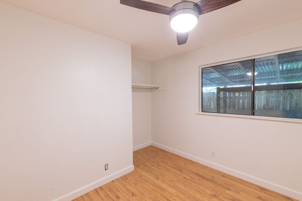 5310 Presidio Road Austin, TX 78745 - Photo 20 of 34 A well-lit bedroom with rich wood flooring and a modern ceiling fan.