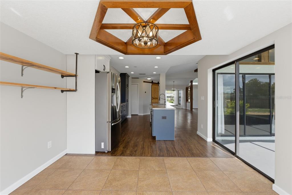 4966 Keysville Avenue Spring Hill, FL 34608 - Photo 24 of 48 a view of a hallway with a dining table and chandelier