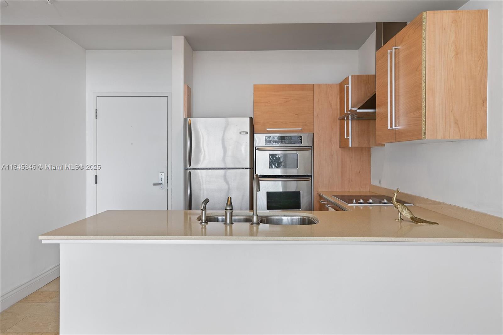 218 Southeast 14th Street, Unit 1904 Miami, FL 33131 - Photo 7 of 28 a kitchen with kitchen island a sink and refrigerator