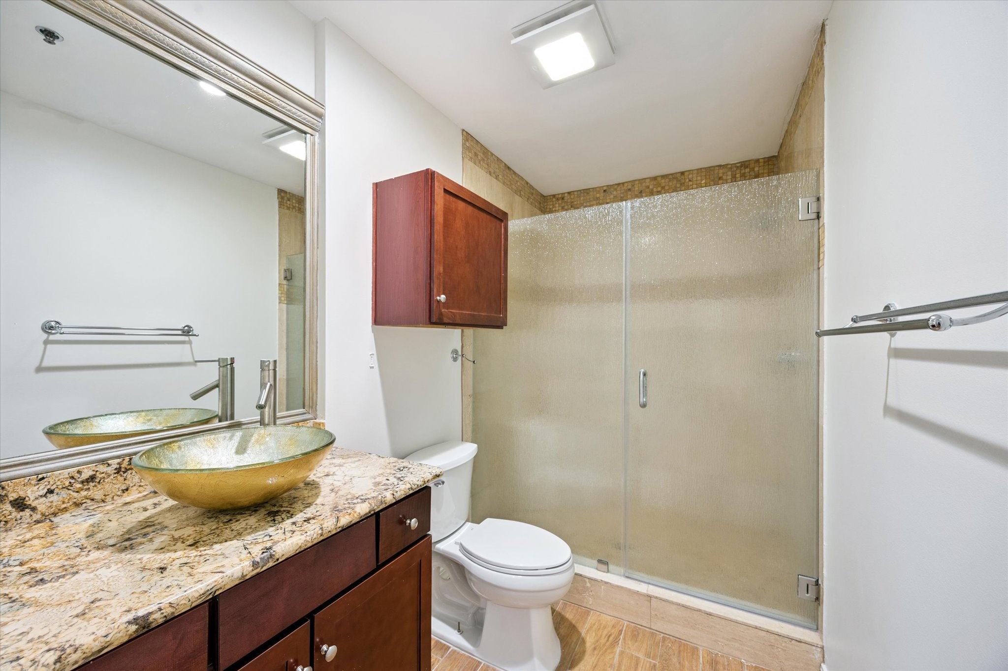 917 Main Street, Unit 1005 Houston, TX 77002 - Photo 10 of 14 a bathroom with a granite countertop sink toilet and shower