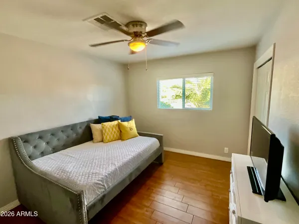 a living room with a bed furniture and a flat screen tv
