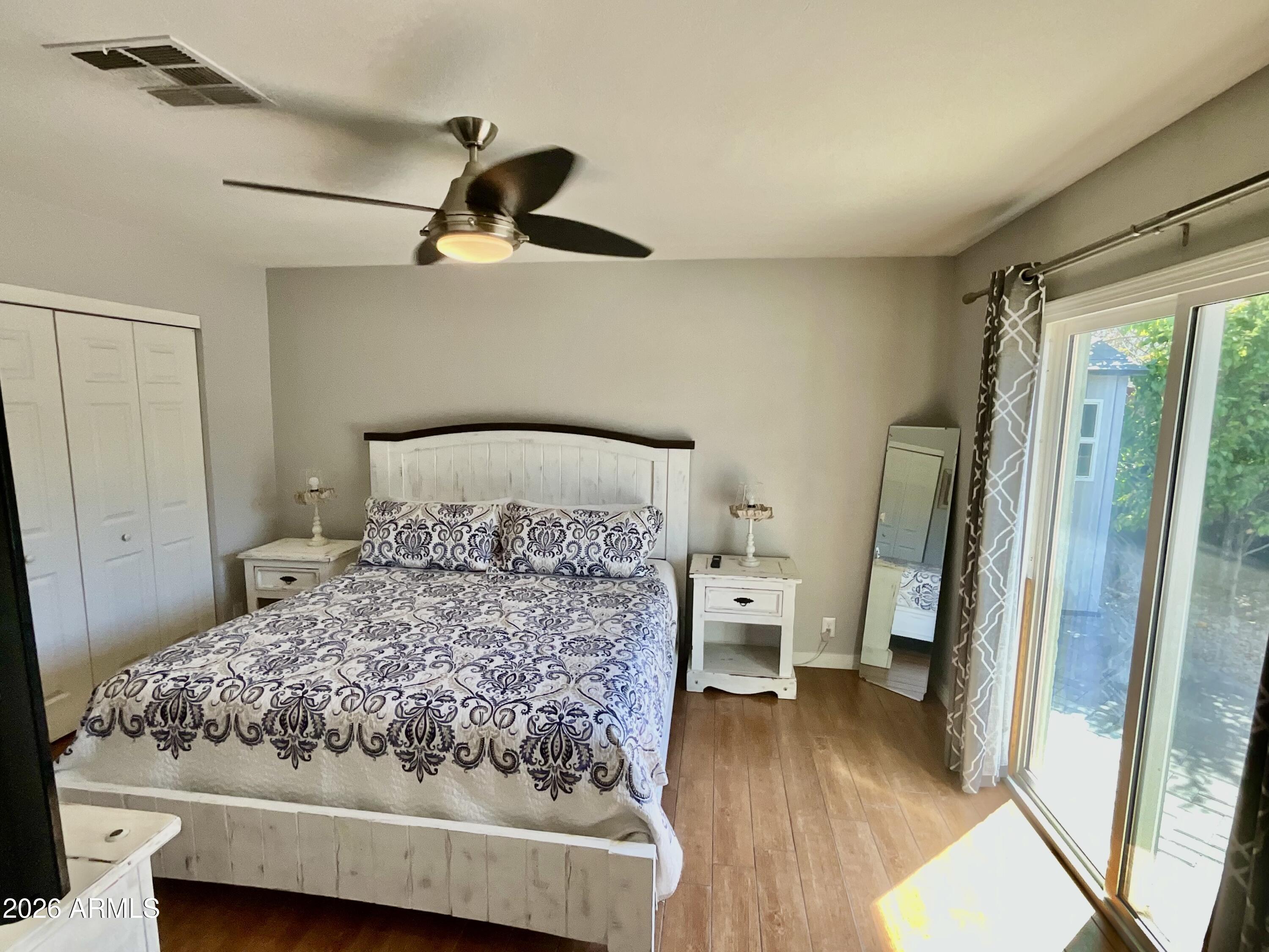 1601 West Lamar Road Phoenix, AZ 85015 - Photo 16 of 28 a bedroom with a bed and wooden floor