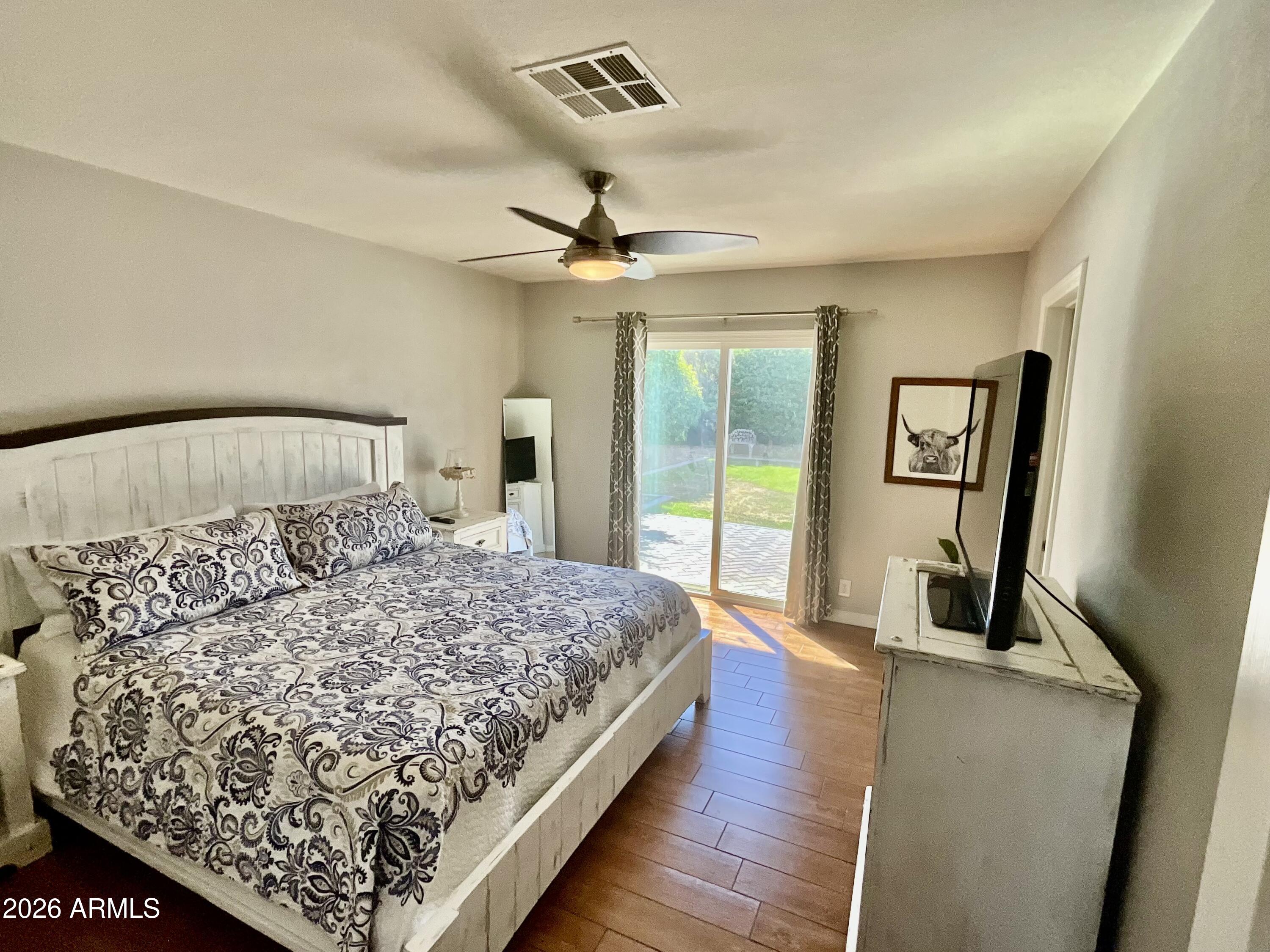 1601 West Lamar Road Phoenix, AZ 85015 - Photo 17 of 28 a bedroom with a large bed and a chandelier
