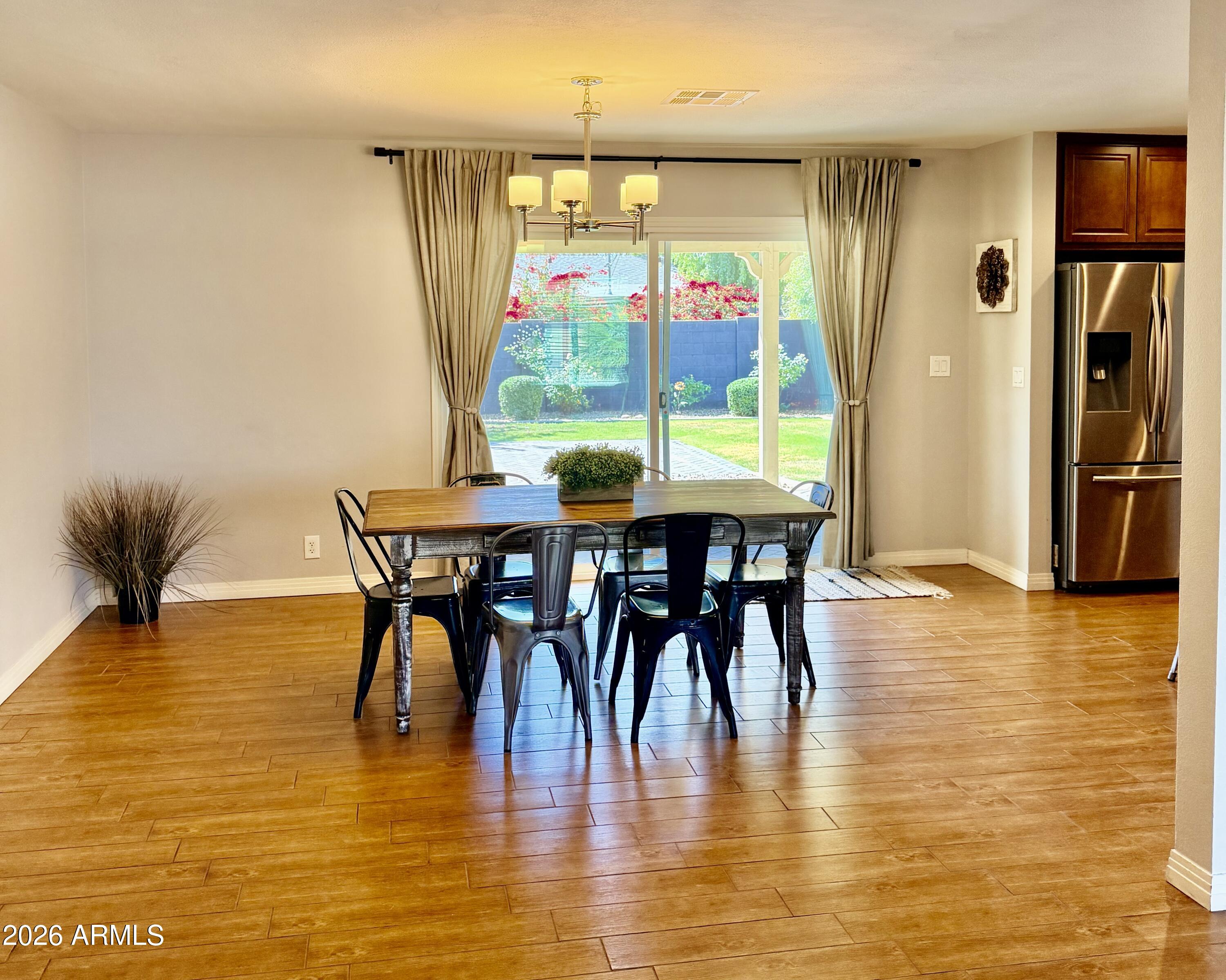 1601 West Lamar Road Phoenix, AZ 85015 - Photo 7 of 28 a view of a dining room with furniture and a floor to ceiling window