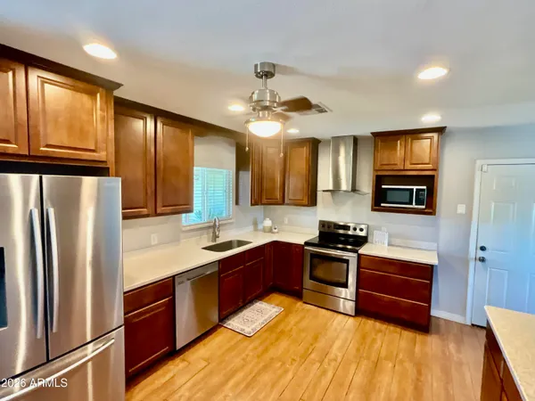 a kitchen with stainless steel appliances granite countertop wooden cabinets a stove top oven a sink and dishwasher