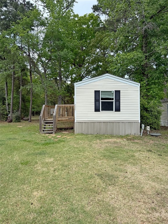 390 Hidden Oaks Drive Point Blank, TX 77364 - Photo 2 of 7 a house with green field in front of it