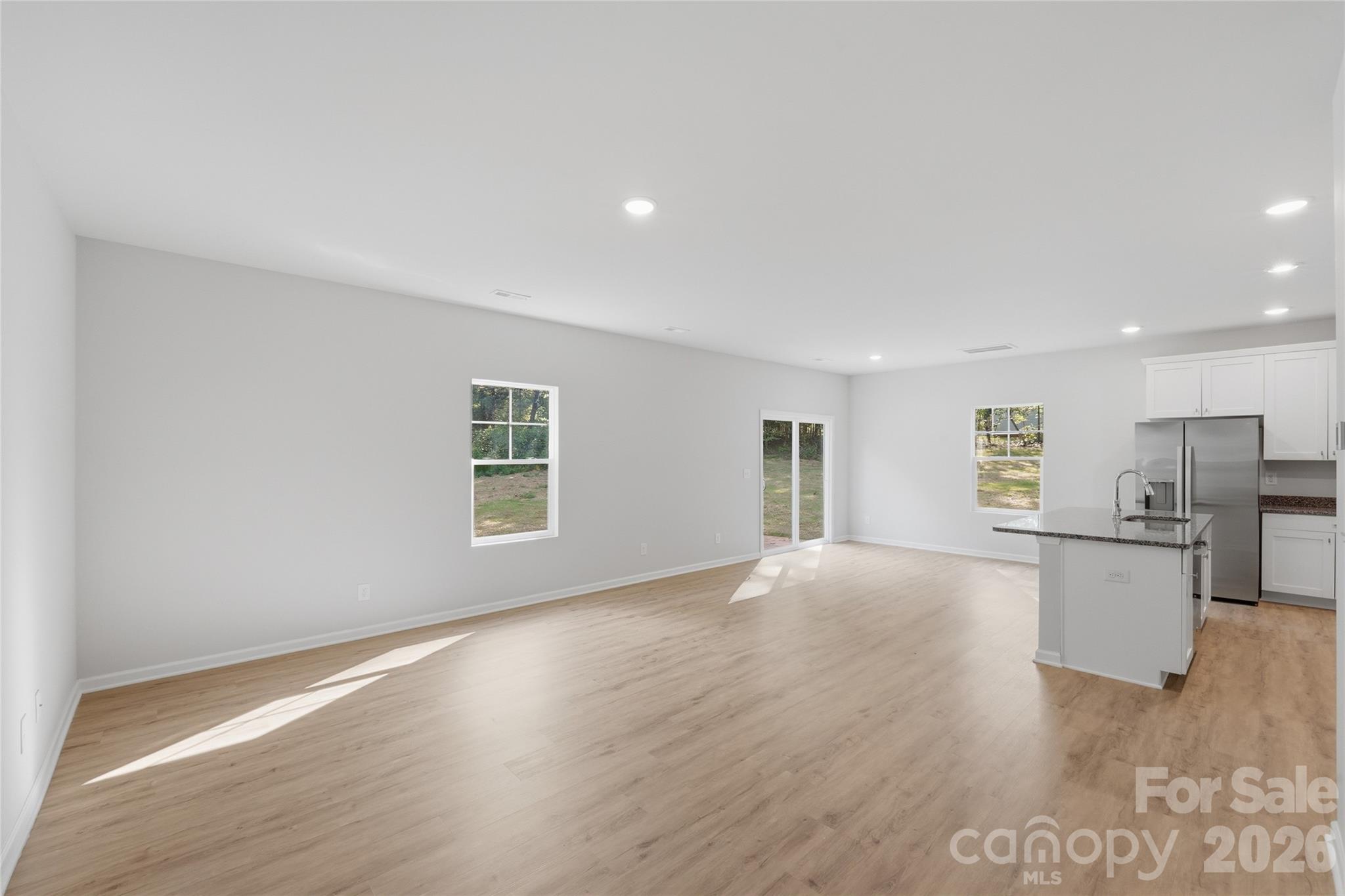 242 Landers Chapel Road Lincolnton, NC 28092 - Photo 10 of 33 a view of empty room with wooden floor and kitchen