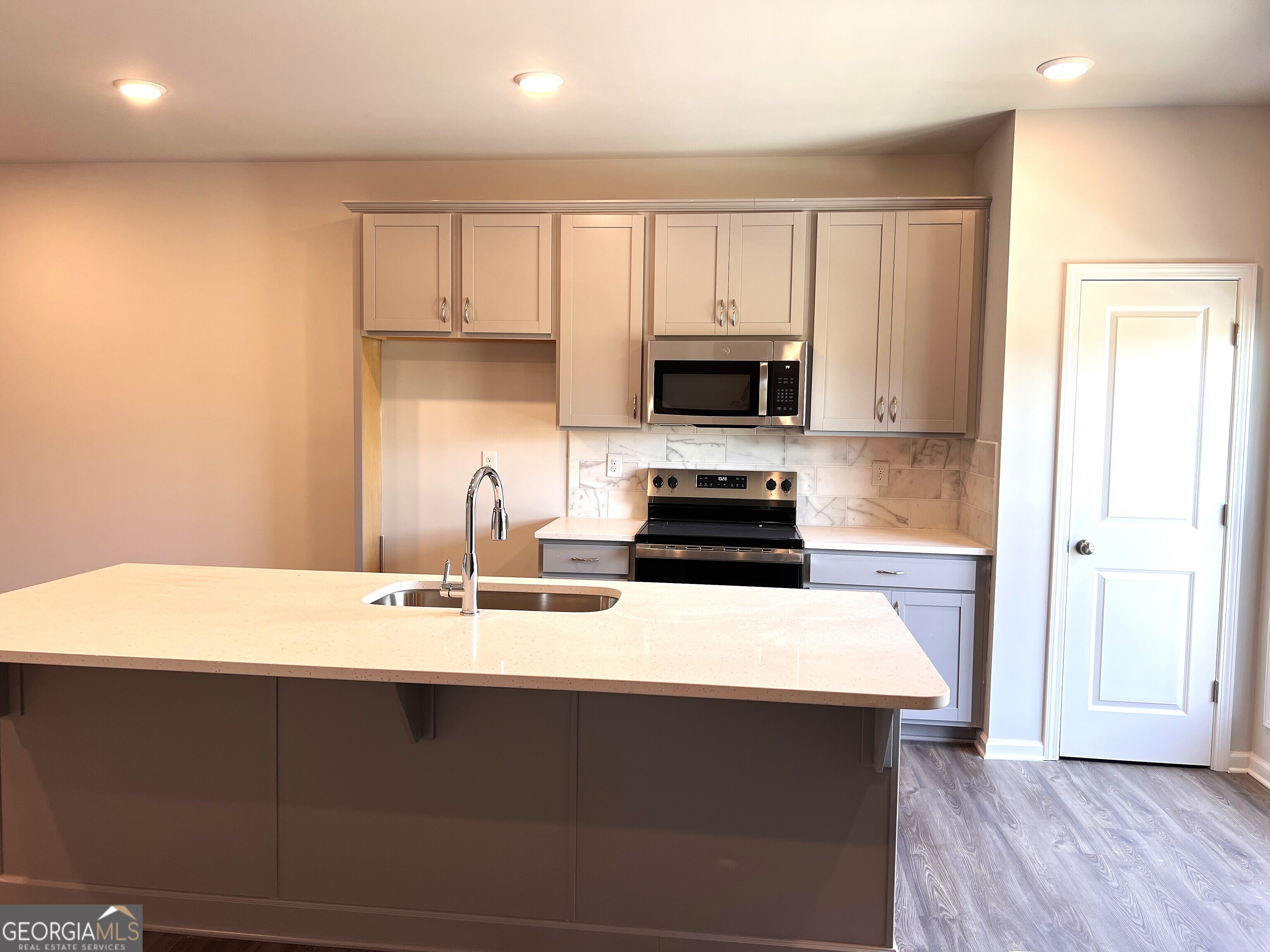 35 Cobalt Lane, Unit 81 Newnan, GA 30265 - Photo 12 of 30 a kitchen with kitchen island a sink appliances and cabinets