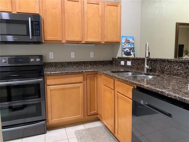 a kitchen with stainless steel appliances granite countertop a stove and a microwave