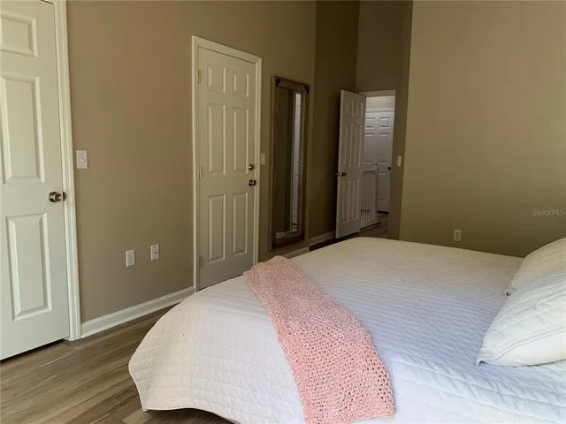 a bedroom with a bed and wooden floor
