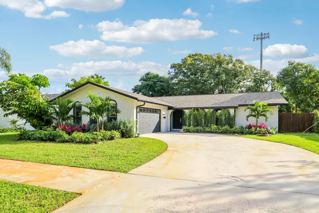 a front view of a house with a yard and potted plants