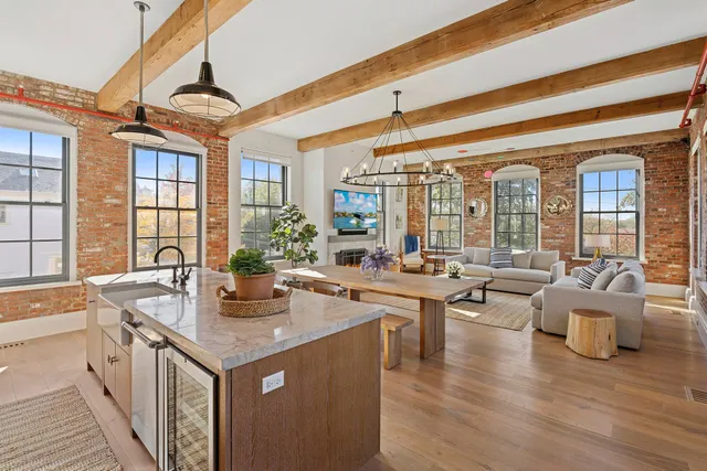 a very nice looking living room with a large window and wooden floor