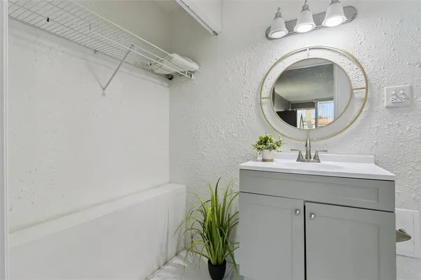 a bathroom with a sink a mirror and vanity
