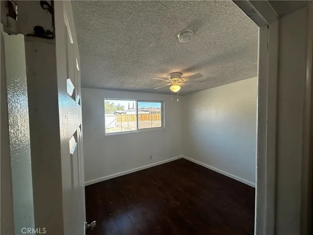en empty room with wooden floor and windows