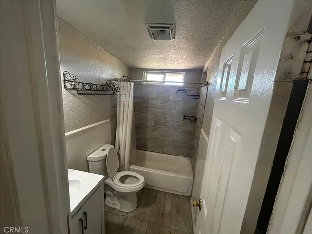 a bathroom with a granite countertop toilet a sink and shower