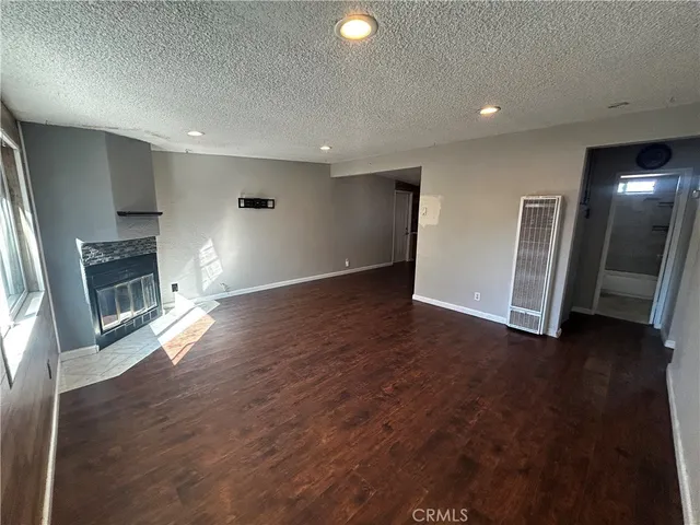 an empty room with wooden floor and fireplace