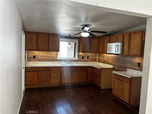 a kitchen with granite countertop cabinets stainless steel appliances a sink and a window