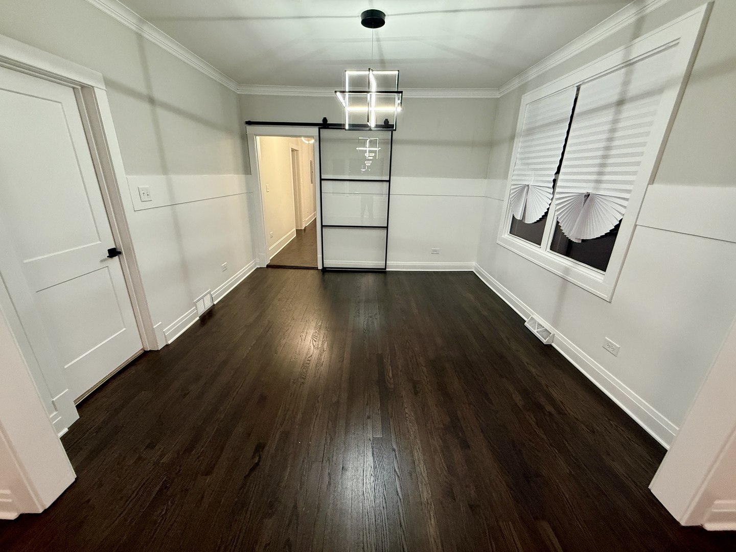 5942 West Eastwood Avenue, Unit 1 Chicago, IL 60630 - Photo 4 of 17 an empty room with wooden floor and windows