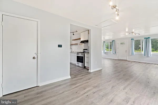 an empty room with wooden floor and windows