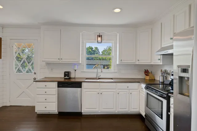 a kitchen with sink cabinets and wooden floor