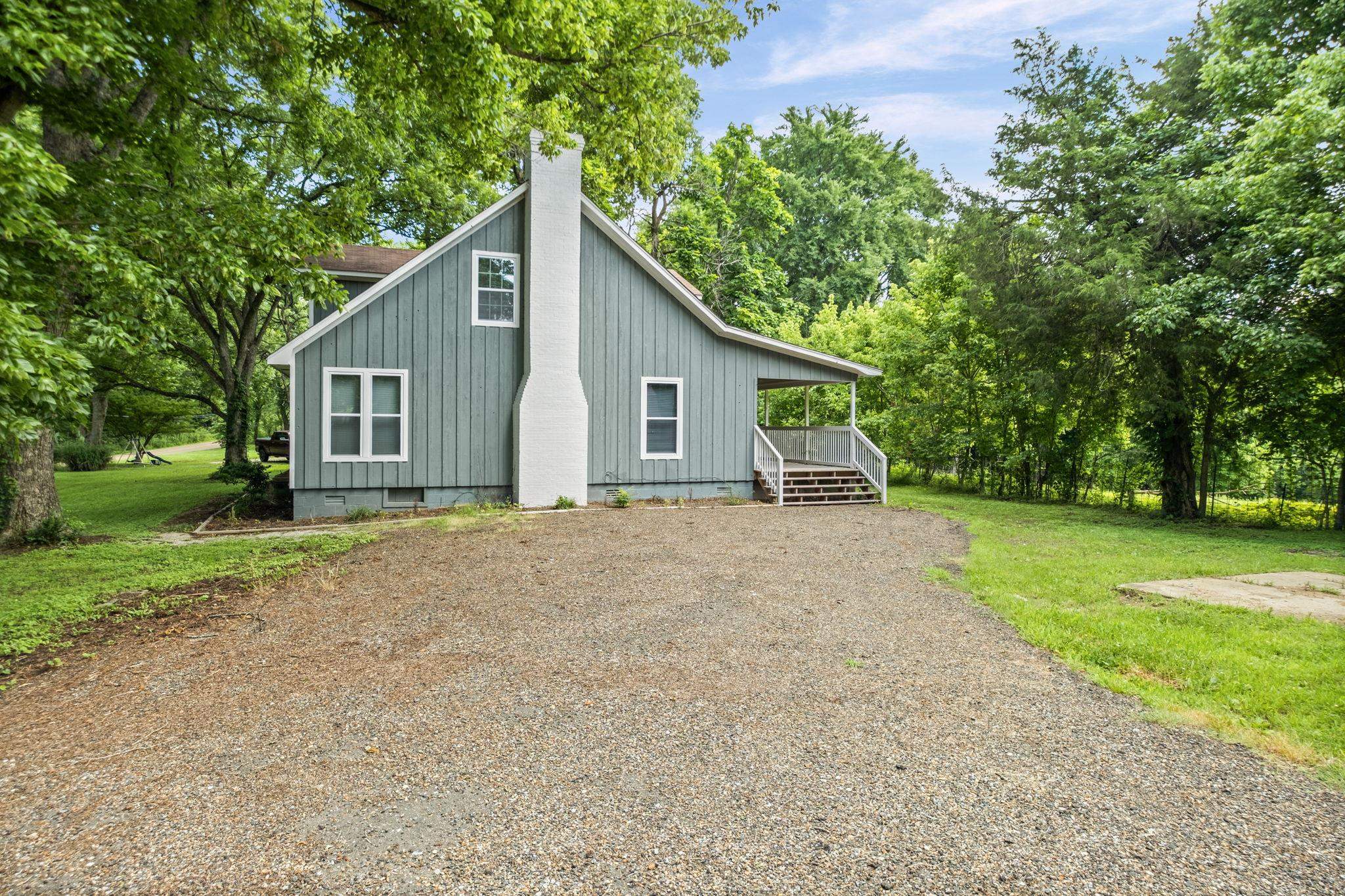 6224 Benjestown Road Memphis, TN 38127 - Photo 36 of 39 Light blue siding exterior featuring a prominent white chimney and white trim