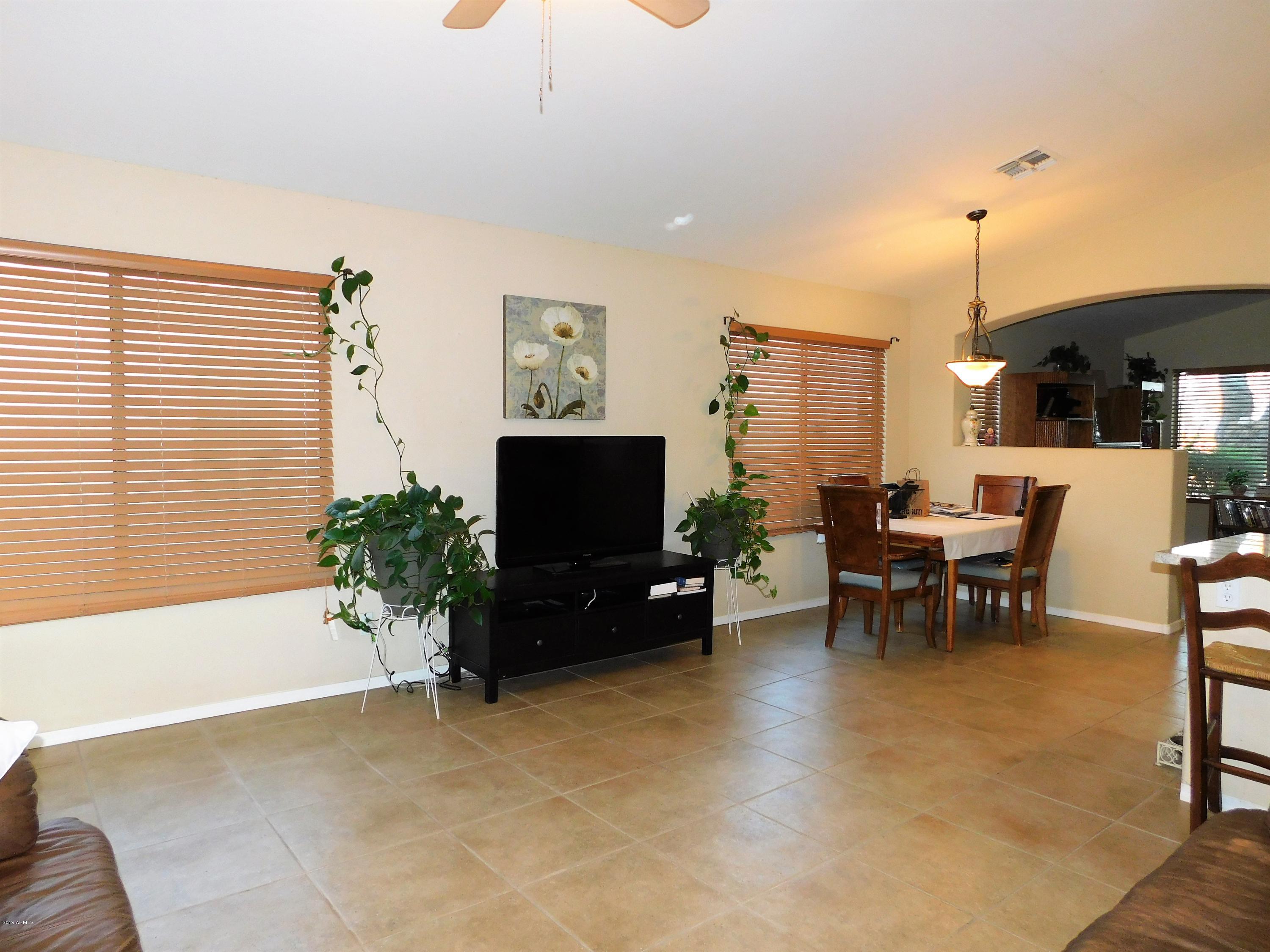 15814 West Jackson Street Goodyear, AZ 85338 - Photo 9 of 18 a living room with furniture a window and a flat screen tv