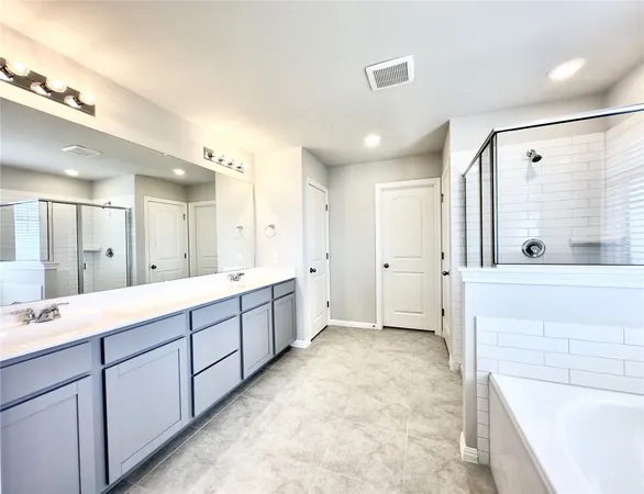 a large bathroom with a large mirror vanity and shower