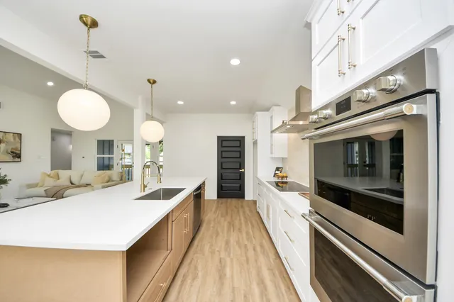 a large kitchen with a large counter top appliances and cabinets