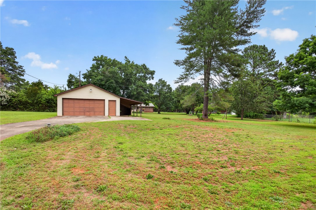 112 Holliday Lane Pendleton, SC 29670 - Photo 41 of 42 A spacious yard with a detached garage and covered parking, offering abundant outdoor utility.