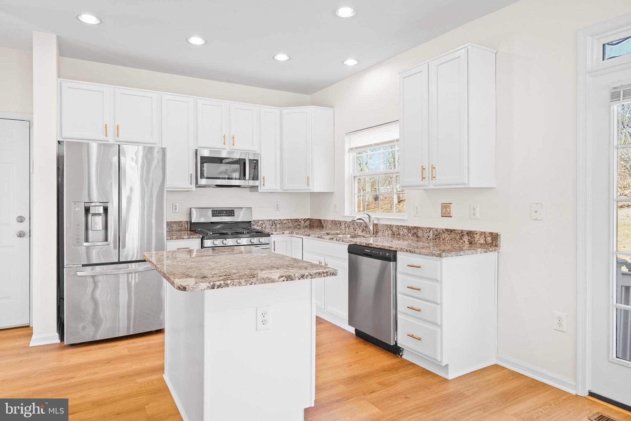 9602 Stuart Lane Clinton, MD 20735 - Photo 14 of 40 a kitchen with stainless steel appliances granite countertop a stove a sink and a refrigerator