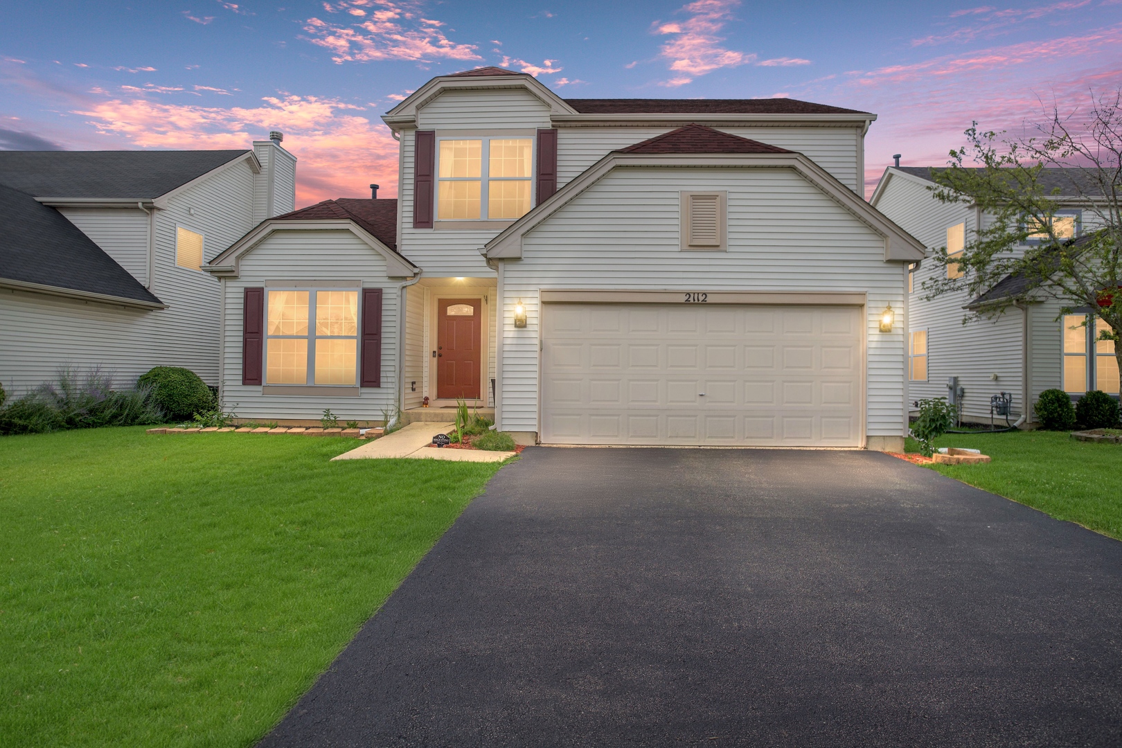 a front view of a house with a yard and garage