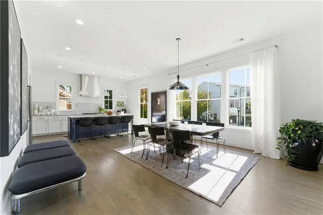 a kitchen with stainless steel appliances kitchen island granite countertop a stove a sink a dining table and chairs