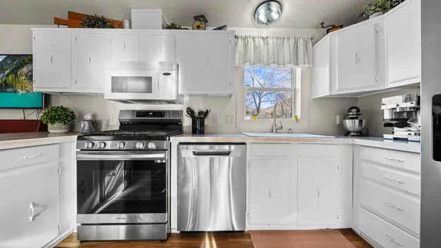 a kitchen with white cabinets and white appliances