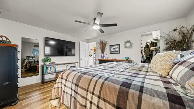 a bed room with a bed a television and a large window