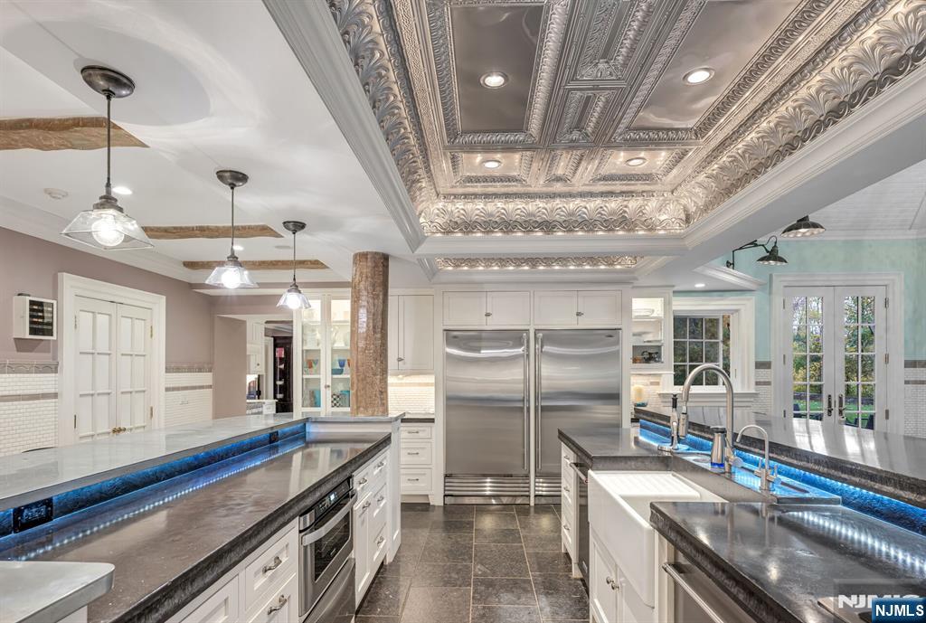 74 Village Road New Vernon, NJ 07976 - Photo 16 of 50 a kitchen with stainless steel appliances granite countertop a large stove a sink dishwasher a refrigerator and a dining table with wooden floor