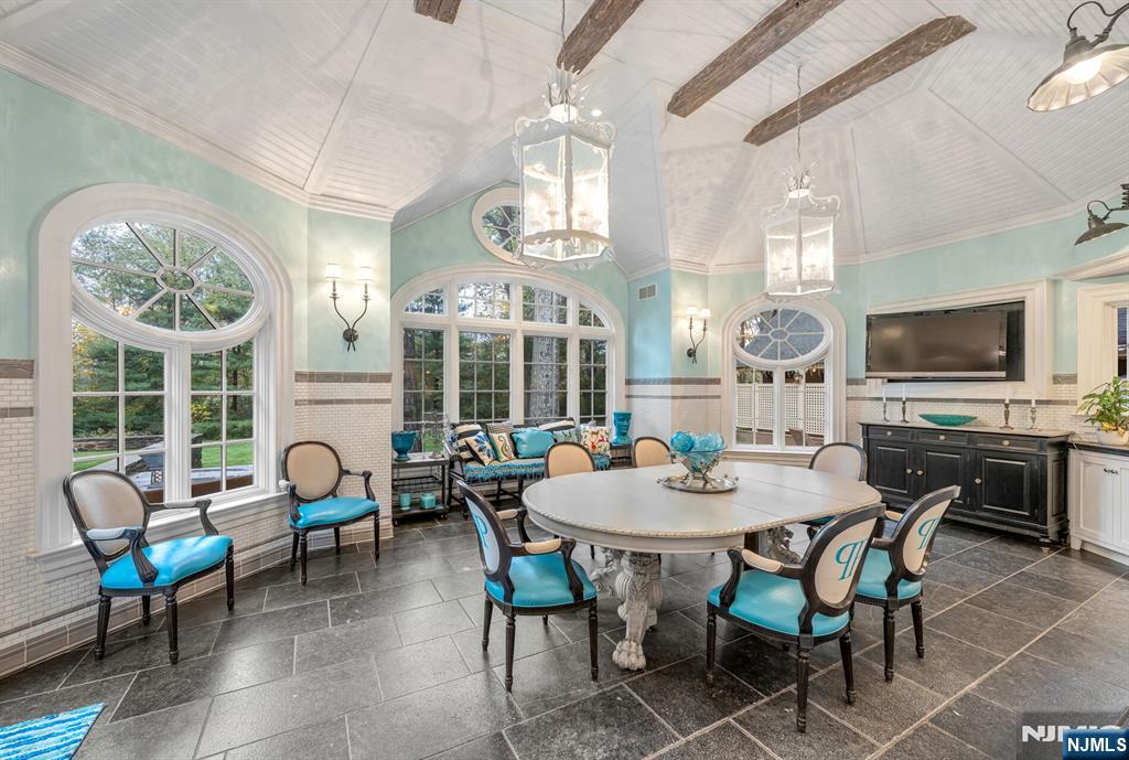 74 Village Road New Vernon, NJ 07976 - Photo 18 of 50 a dining room with wooden floor a chandelier a wooden table and chairs
