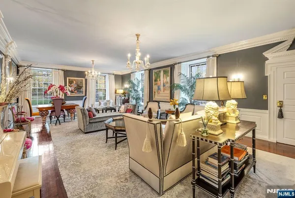 a living room with furniture a chandelier and a dining table