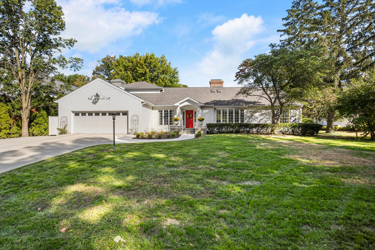 a front view of a house with a yard and trees