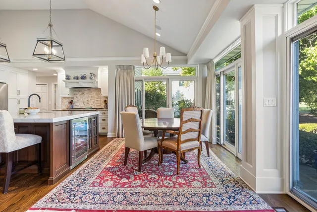 a kitchen with a table chairs stove and wooden floor