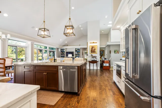 a kitchen with stainless steel appliances granite countertop a stove and a wooden floor