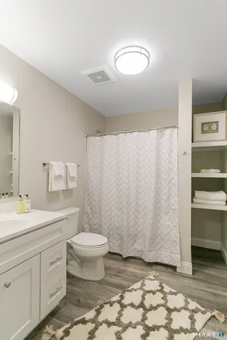 a bathroom with a sink a toilet and shower