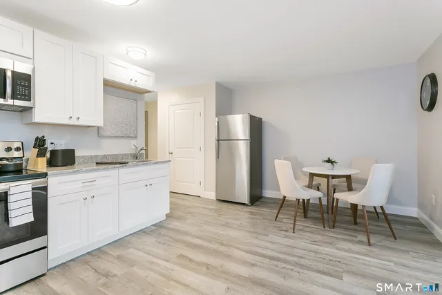 a kitchen with a dining table chairs refrigerator and cabinets