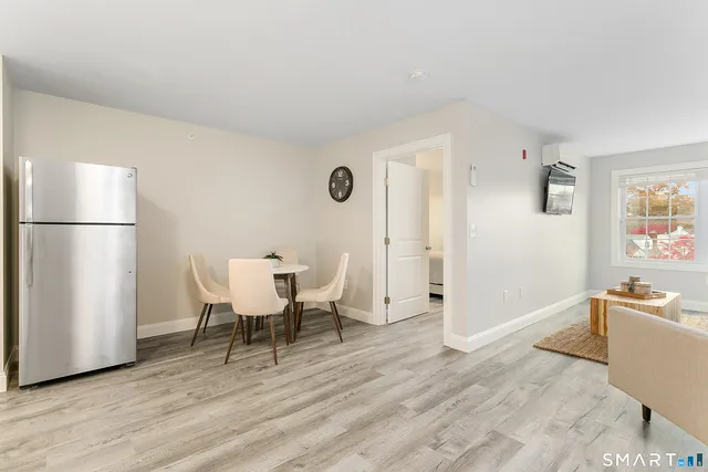 a view of a kitchen with refrigerator and wooden floor