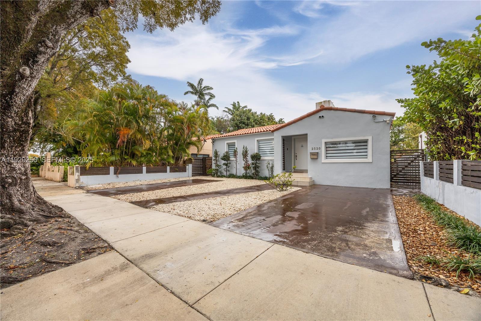 a view of a house with a yard and large tree
