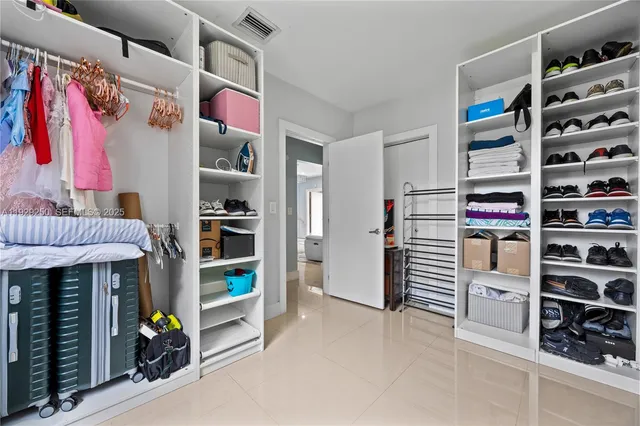 a view of walk in closet with clothes and shoes
