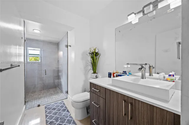 a bathroom with a sink a toilet and shower