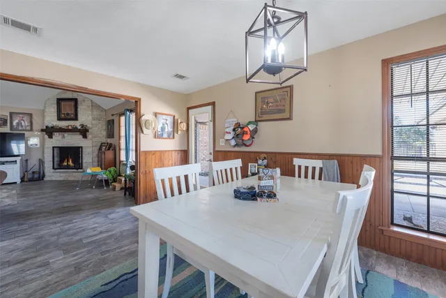 a view of a dining room with furniture a chandelier and wooden floor