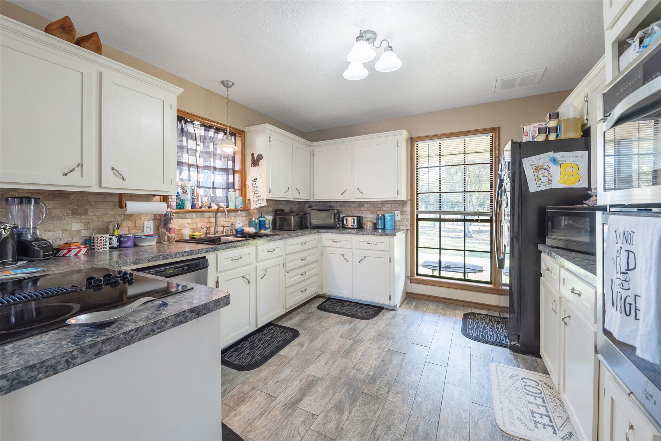 1014 Ginger Street Santa Fe, TX 77517 - Photo 13 of 50 a kitchen with stainless steel appliances white cabinets a stove a sink and a window